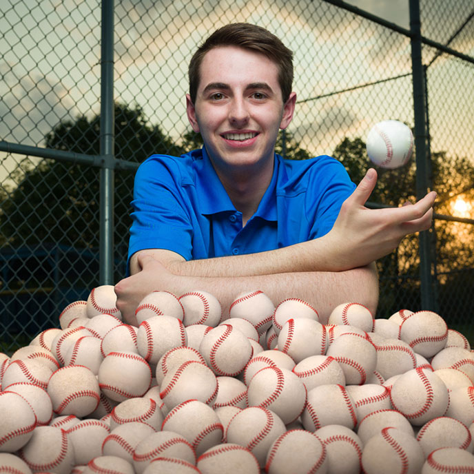 Henry Shires poses with alot of baseballs