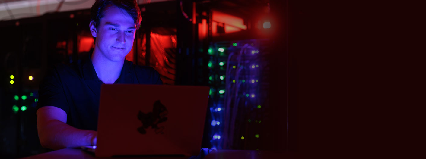 student at laptop in dark room